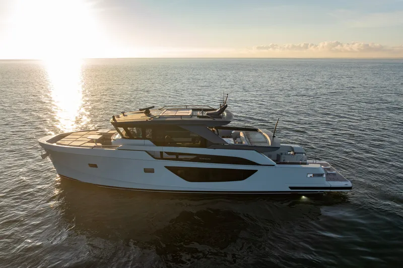 The Calm Down Yacht Photos Pics 2024 Bluegame BGX63 yacht cruising at sunset on calm ocean waters.