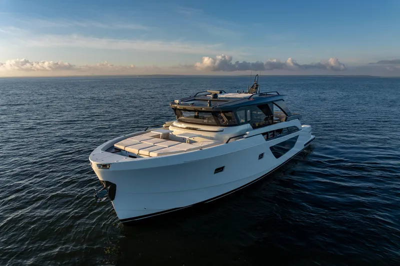 The Calm Down Yacht Photos Pics 2024 Bluegame BGX63 yacht cruising on open sea at sunset.