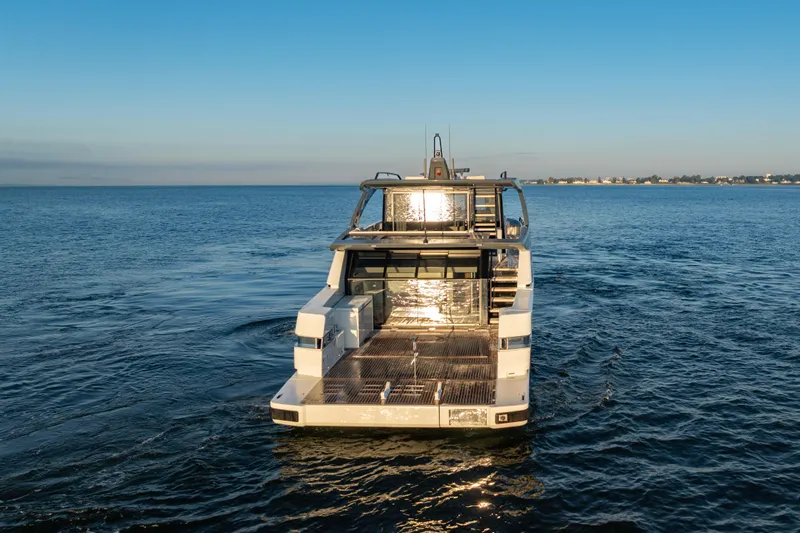 The Calm Down Yacht Photos Pics 2024 Bluegame BGX63 yacht cruising on open water at sunset.
