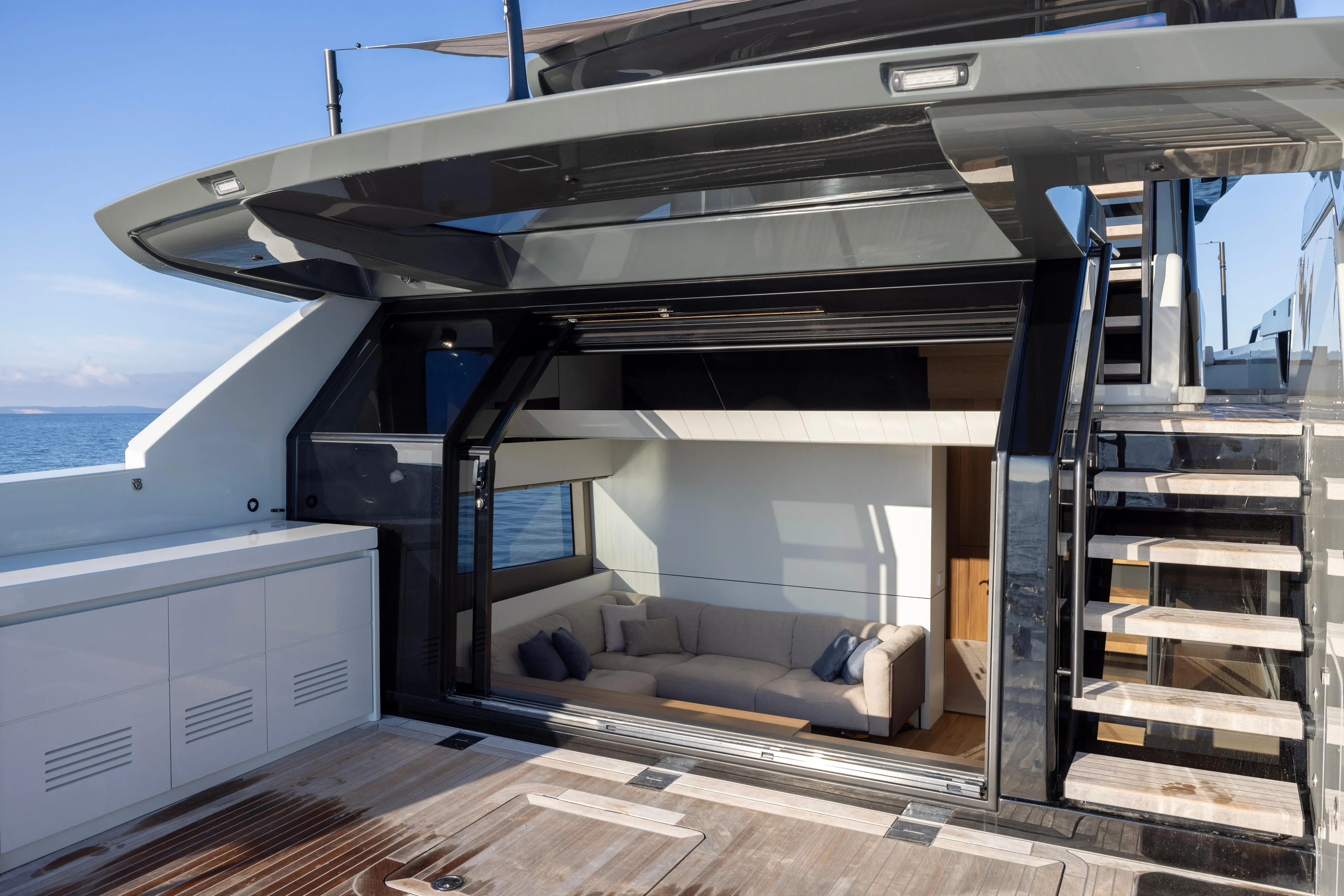 The Calm Down Yacht Photos Pics 2024 Bluegame BGX63 yacht interior with modern design, featuring a cozy seating area and sleek staircase.