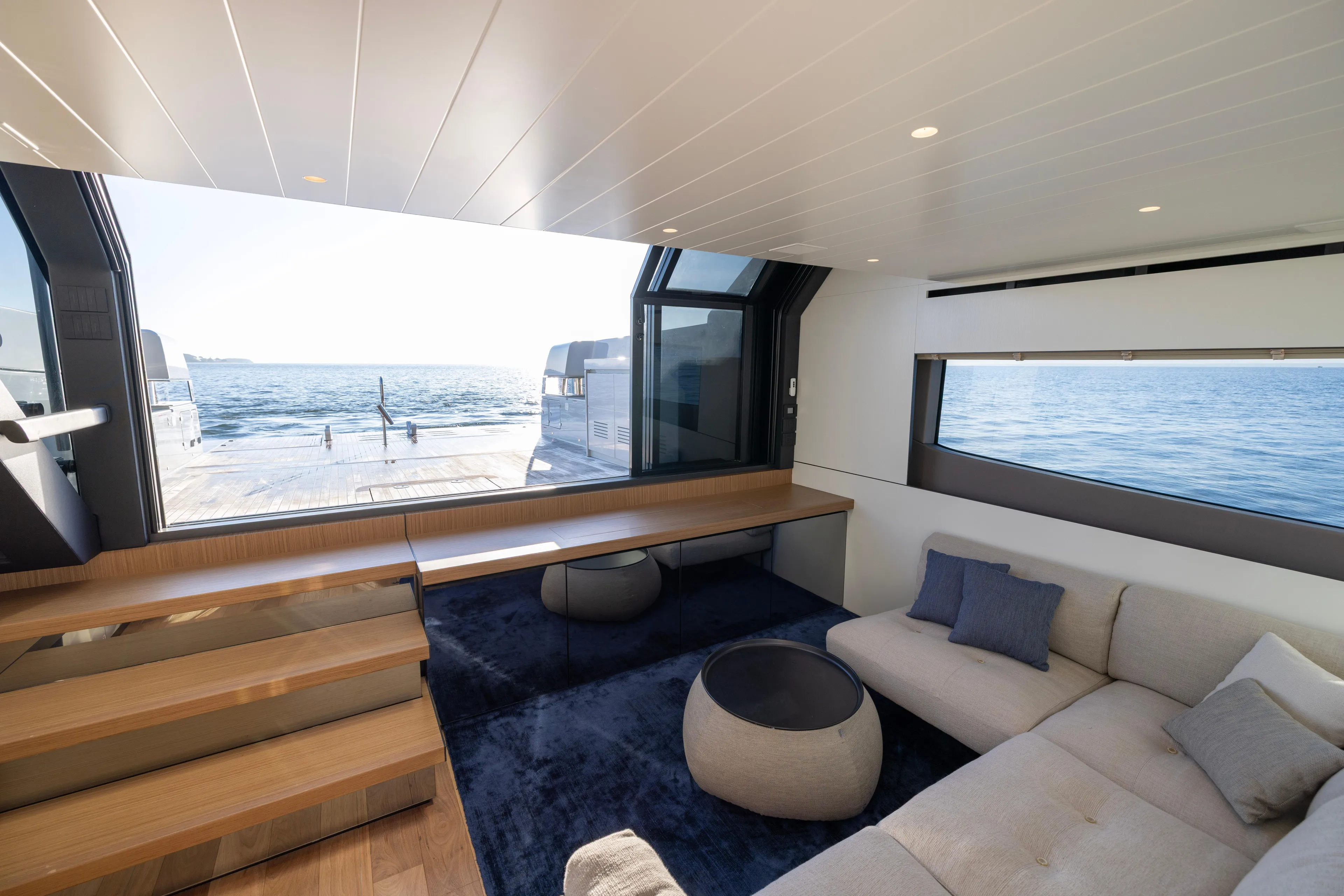 The Calm Down Yacht Photos Pics Luxurious interior of 2024 Bluegame BGX63 yacht with ocean view through large windows.