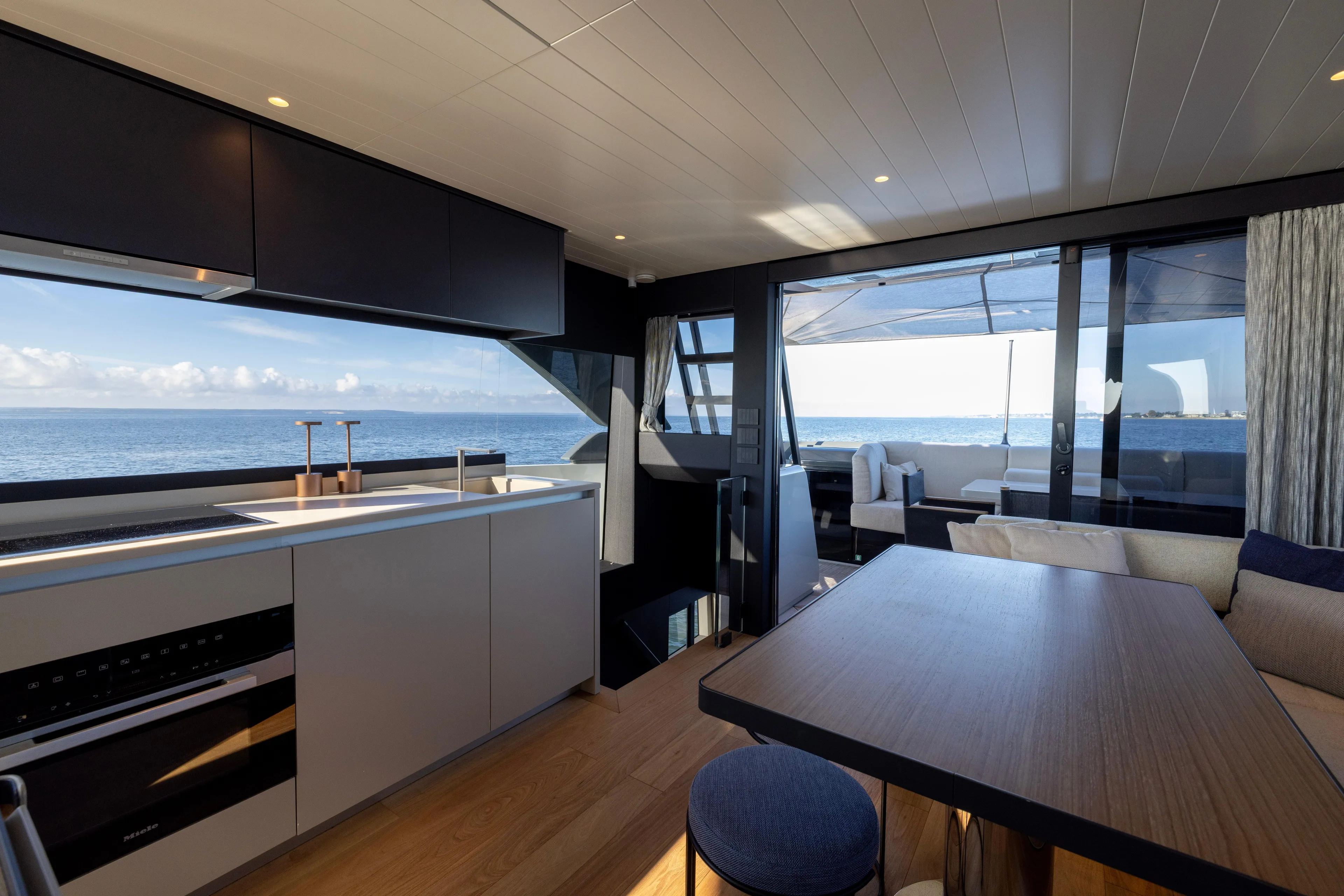 The Calm Down Yacht Photos Pics Luxurious interior of 2024 Bluegame BGX63 yacht with ocean view and modern kitchen.