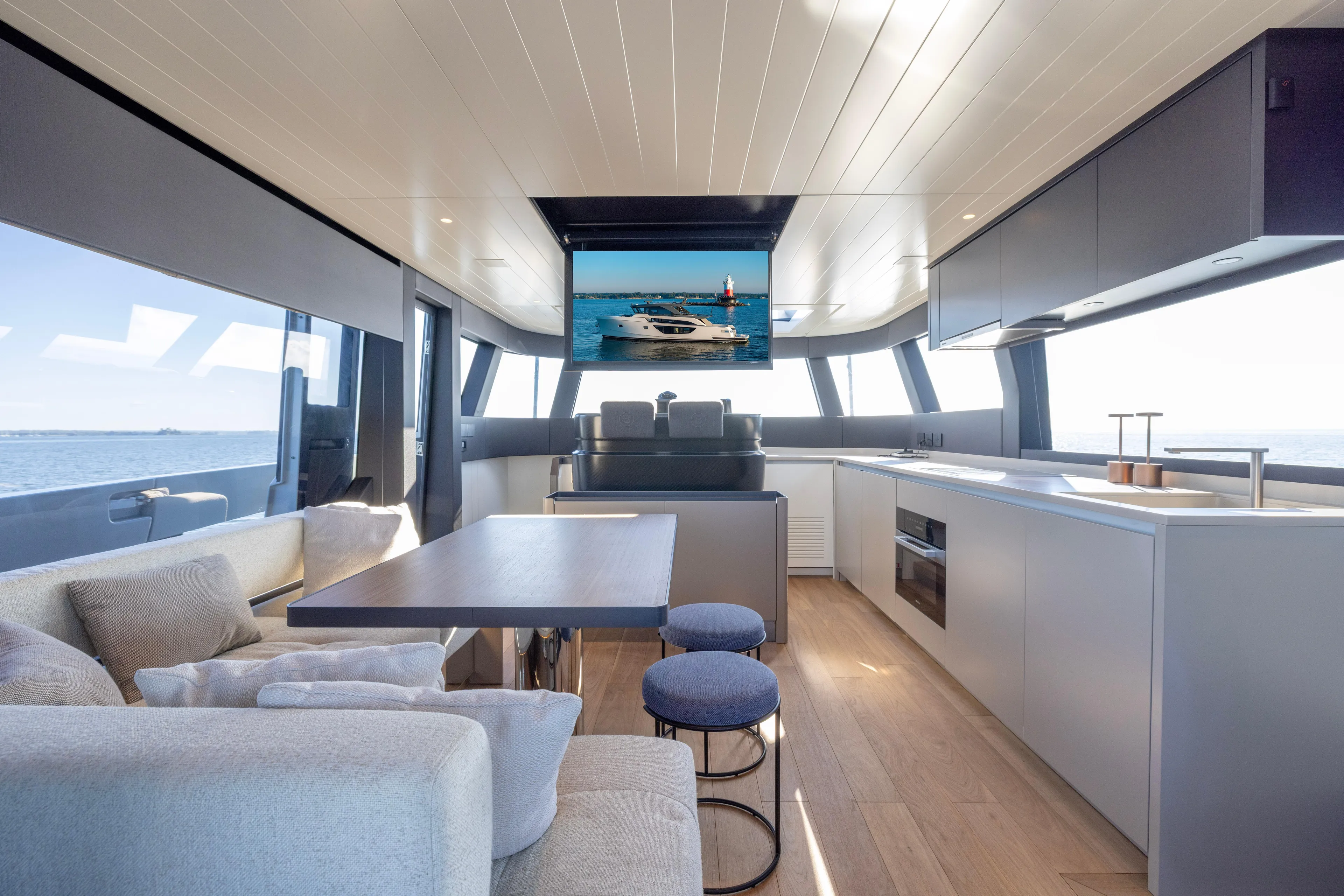The Calm Down Yacht Photos Pics Luxurious interior of 2024 Bluegame BGX63 yacht with modern kitchen and seating area.