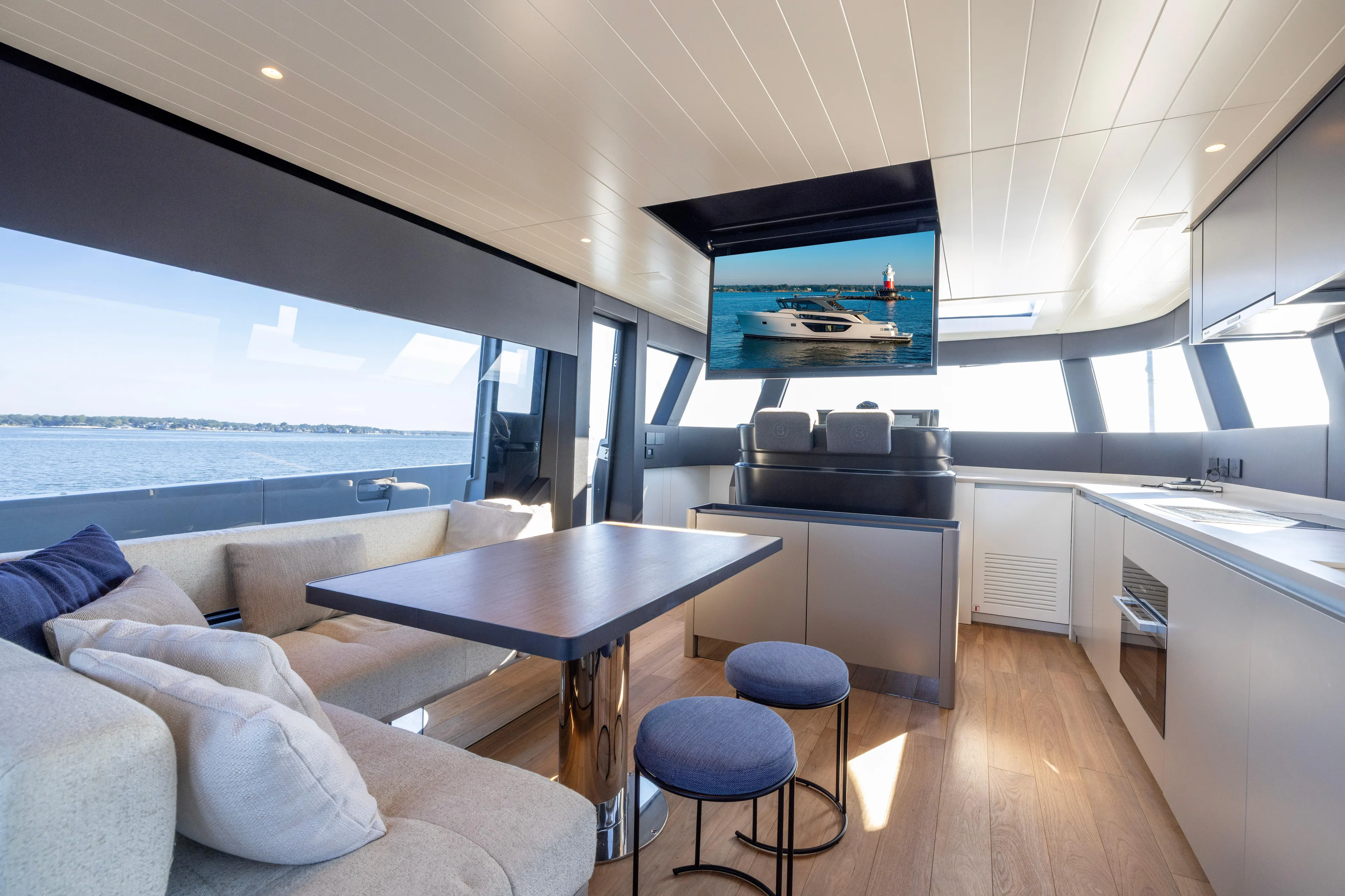The Calm Down Yacht Photos Pics Luxurious interior of 2024 Bluegame BGX63 yacht with modern kitchen and seating area.