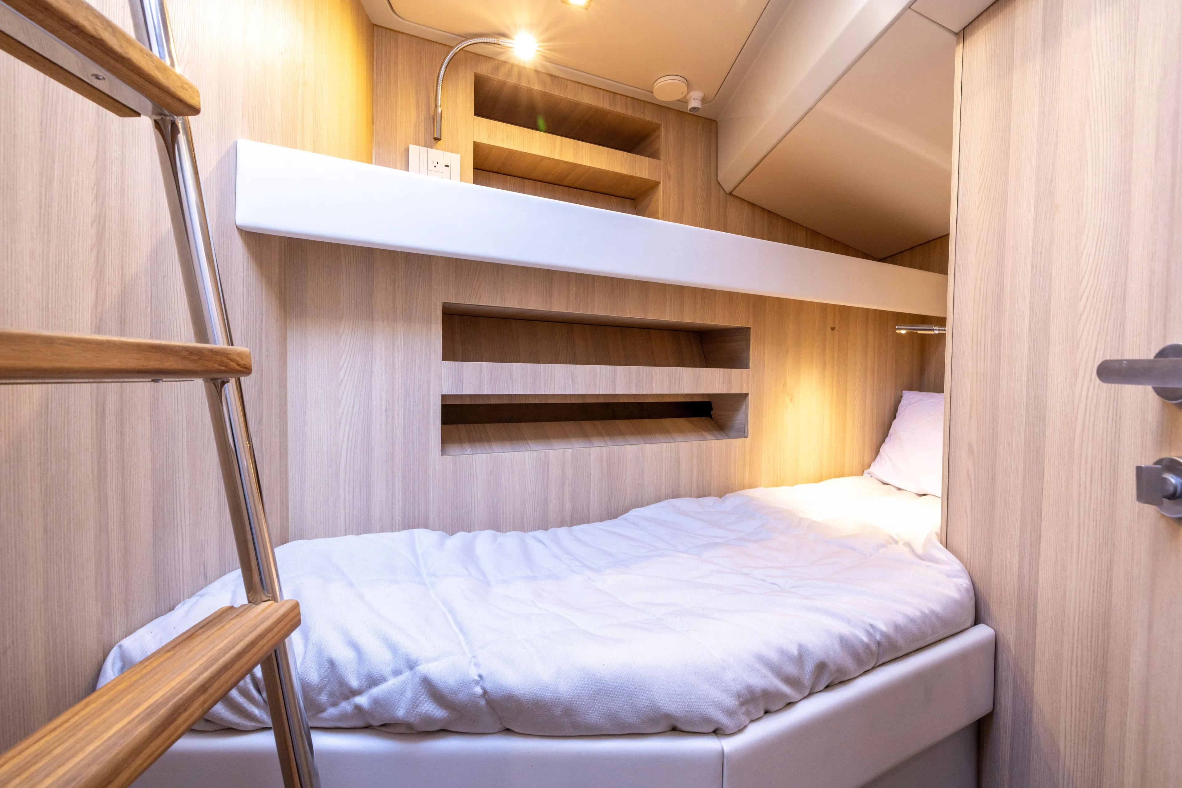 The Calm Down Yacht Photos Pics 2024 Bluegame BGX63 yacht cabin with wooden interior and cozy bed.