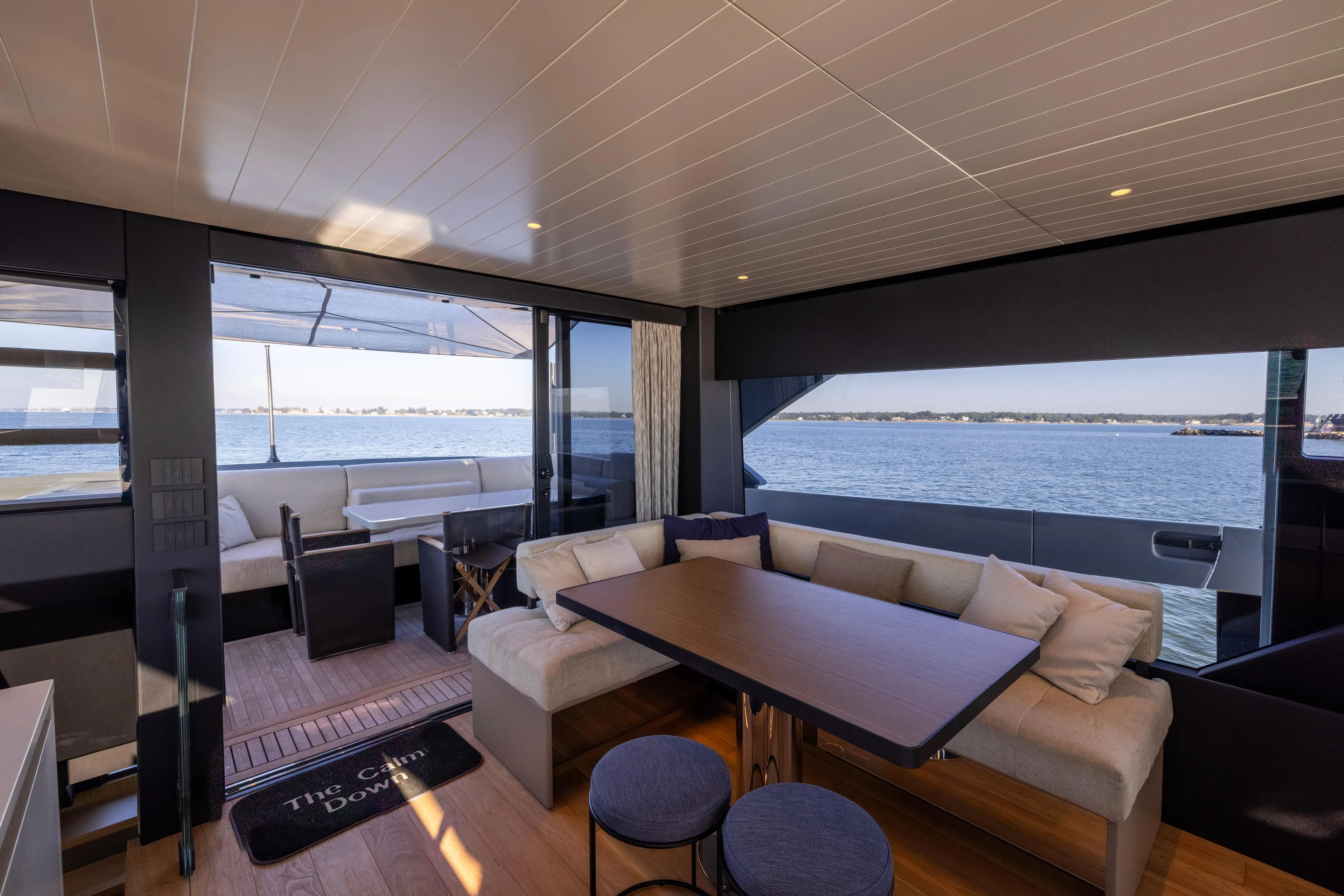 The Calm Down Yacht Photos Pics Luxurious interior of 2024 Bluegame BGX63 yacht with ocean view and modern seating area.