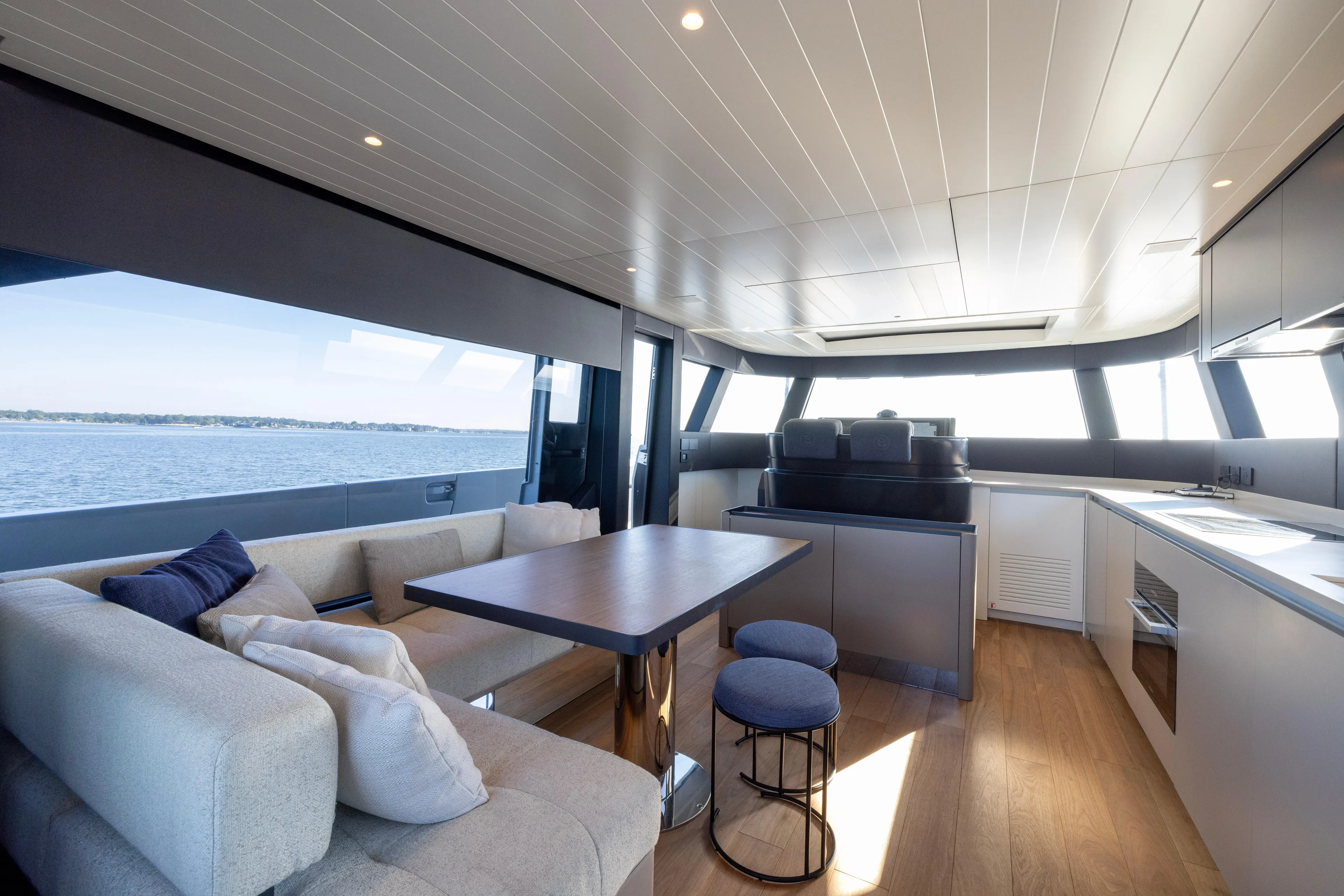 The Calm Down Yacht Photos Pics Luxurious interior of 2024 Bluegame BGX63 yacht with modern seating and panoramic windows.
