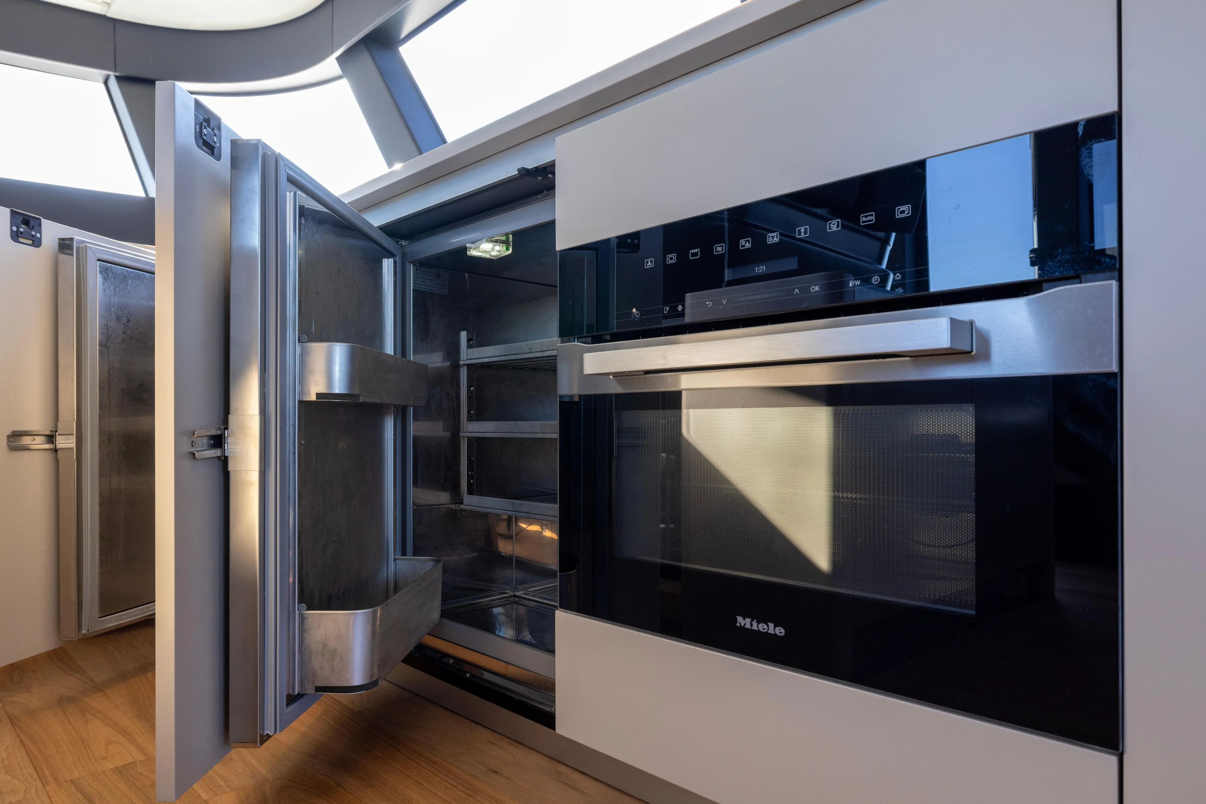The Calm Down Yacht Photos Pics Modern kitchen appliances on 2024 Bluegame BGX63 yacht, featuring Miele oven and open refrigerator.