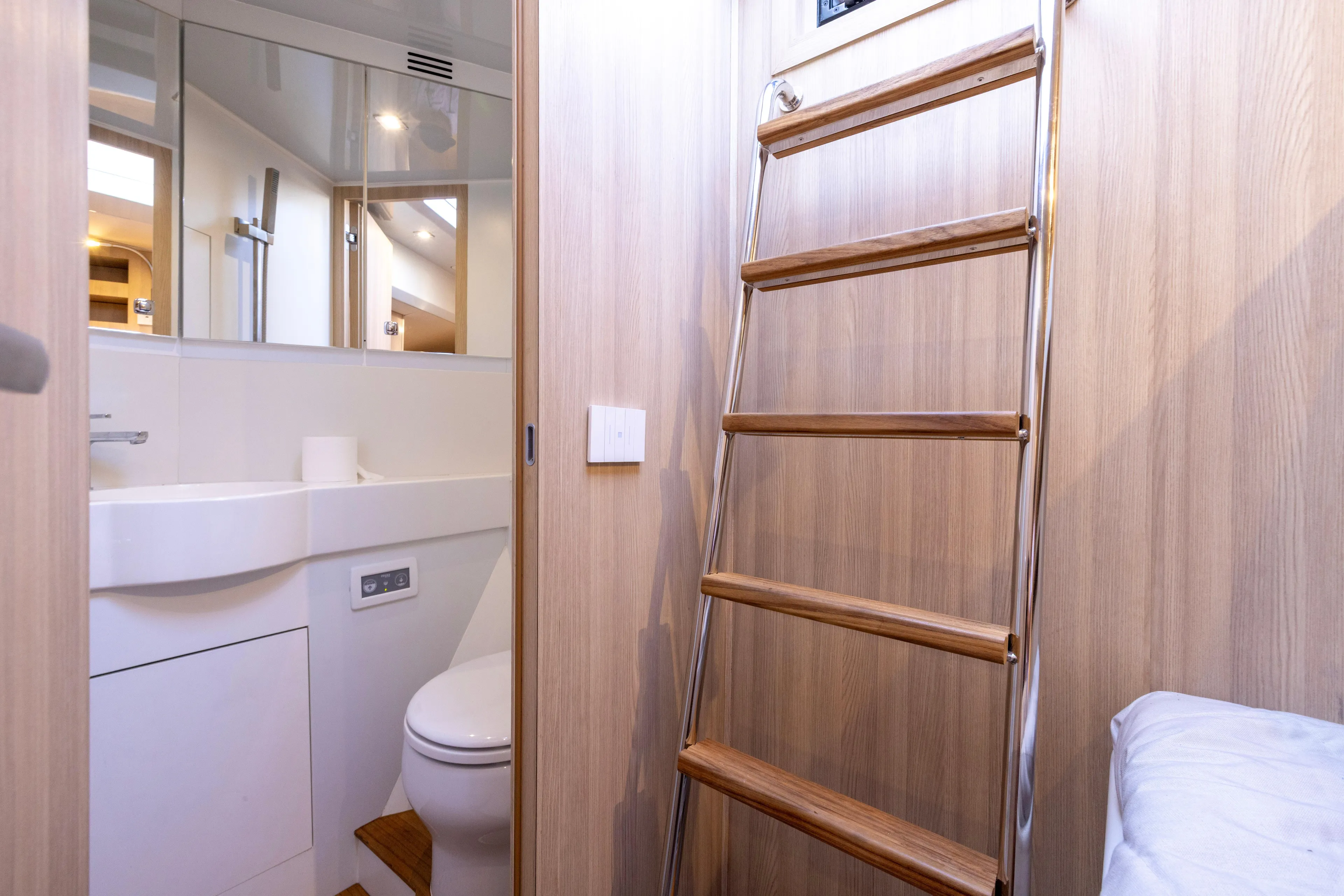 The Calm Down Yacht Photos Pics 2024 Bluegame BGX63 yacht interior with wooden ladder and modern bathroom.