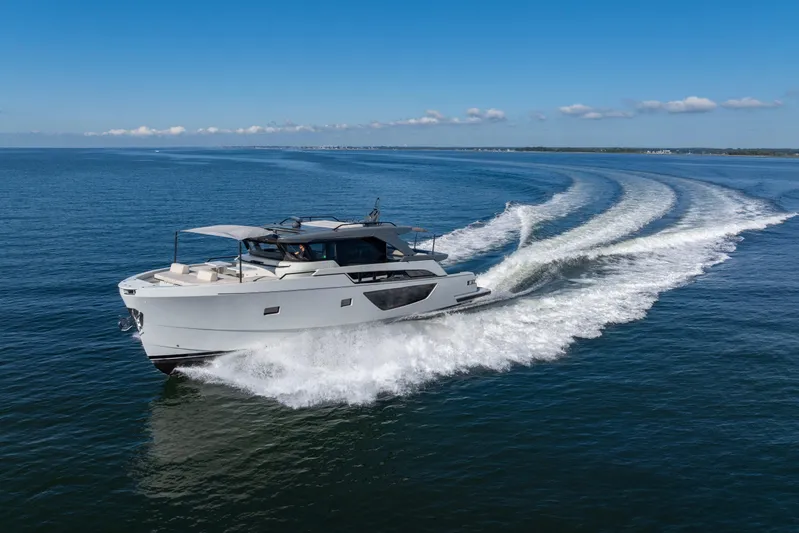 The Calm Down Yacht Photos Pics 2024 Bluegame BGX63 yacht cruising on open water under clear blue skies.