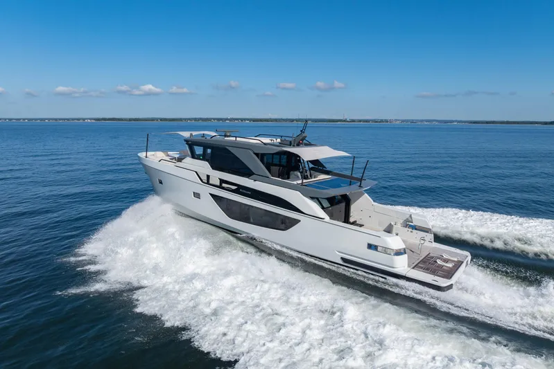 The Calm Down Yacht Photos Pics 2024 Bluegame BGX63 yacht cruising on open water under clear blue skies.