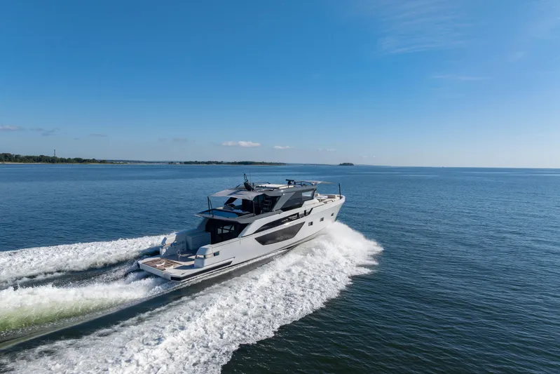 The Calm Down Yacht Photos Pics 2024 Bluegame BGX63 yacht cruising on open water under clear blue skies.