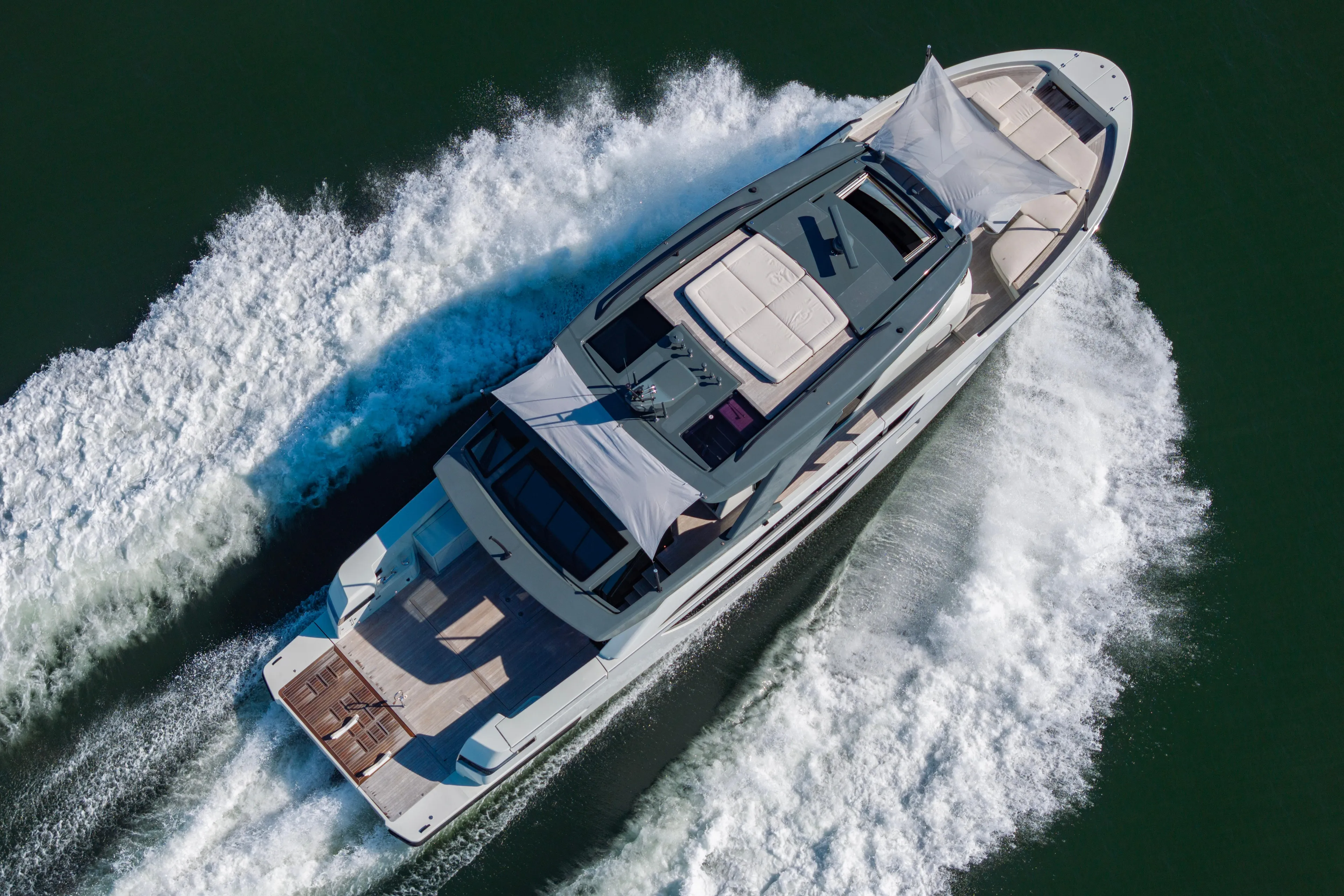 The Calm Down Yacht Photos Pics 2024 Bluegame BGX63 yacht cruising on open water, aerial view.