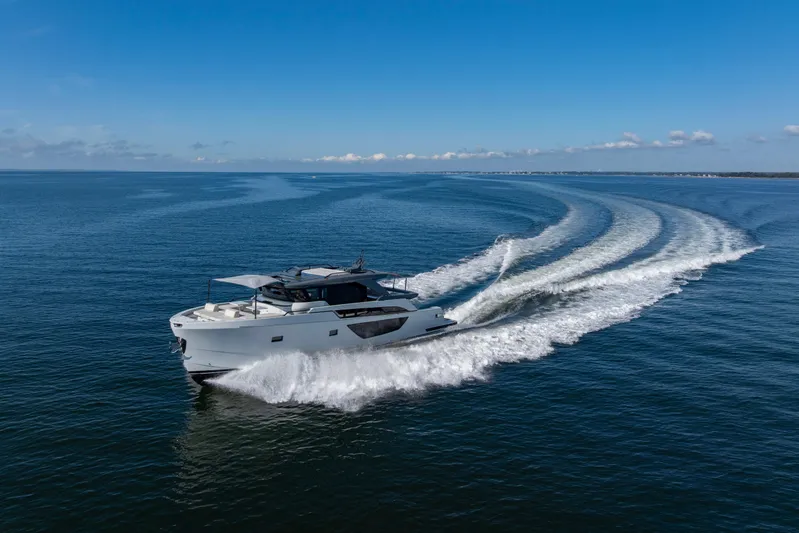 The Calm Down Yacht Photos Pics 2024 Bluegame BGX63 yacht cruising on open sea under clear blue sky.