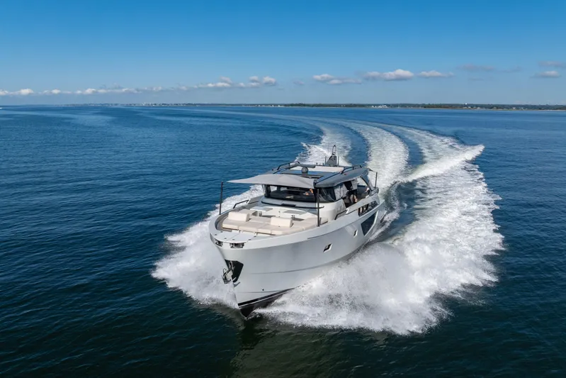 The Calm Down Yacht Photos Pics 2024 Bluegame BGX63 yacht cruising on open water under clear blue skies.