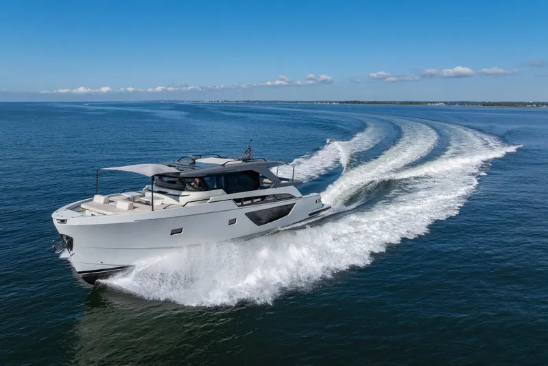 The Calm Down Yacht Photos Pics 2024 Bluegame BGX63 yacht cruising on open water under clear blue skies.