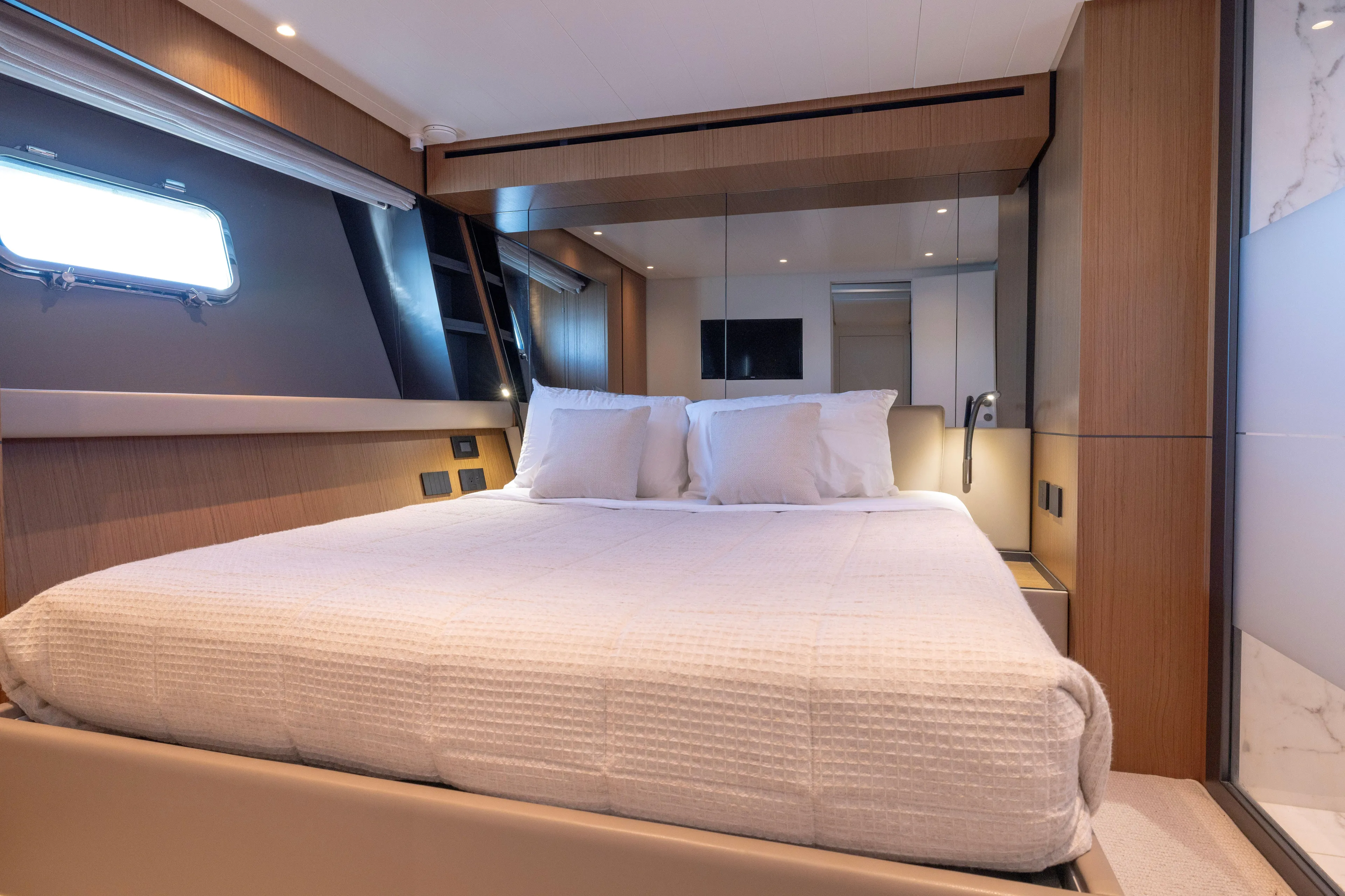 The Calm Down Yacht Photos Pics Luxurious cabin interior of 2024 Bluegame BGX63 yacht with modern design and cozy bedding.