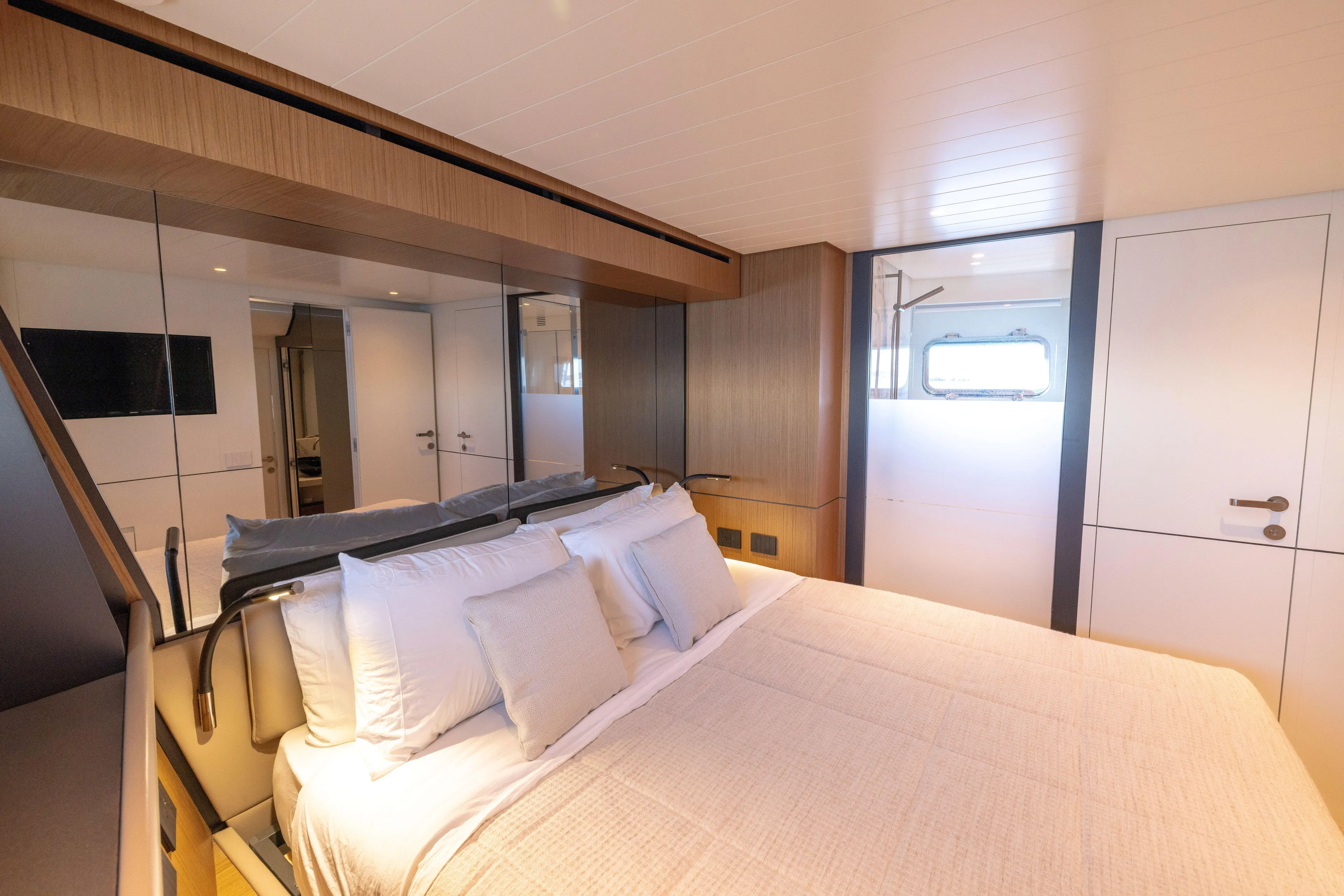 The Calm Down Yacht Photos Pics Luxurious bedroom interior of 2024 Bluegame BGX63 yacht with modern design and cozy bedding.