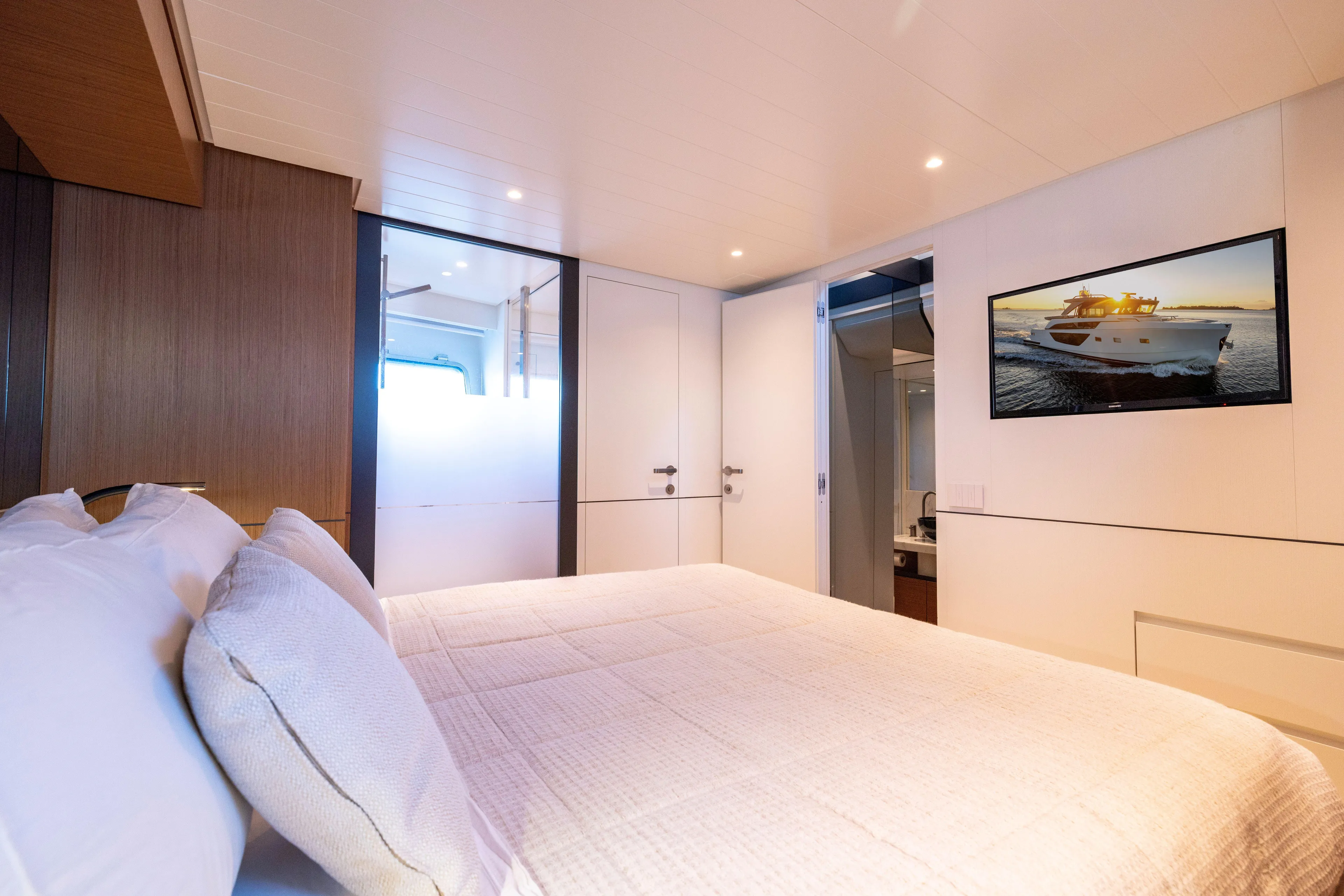 The Calm Down Yacht Photos Pics Luxurious interior of 2024 Bluegame BGX63 yacht bedroom with modern decor and amenities.