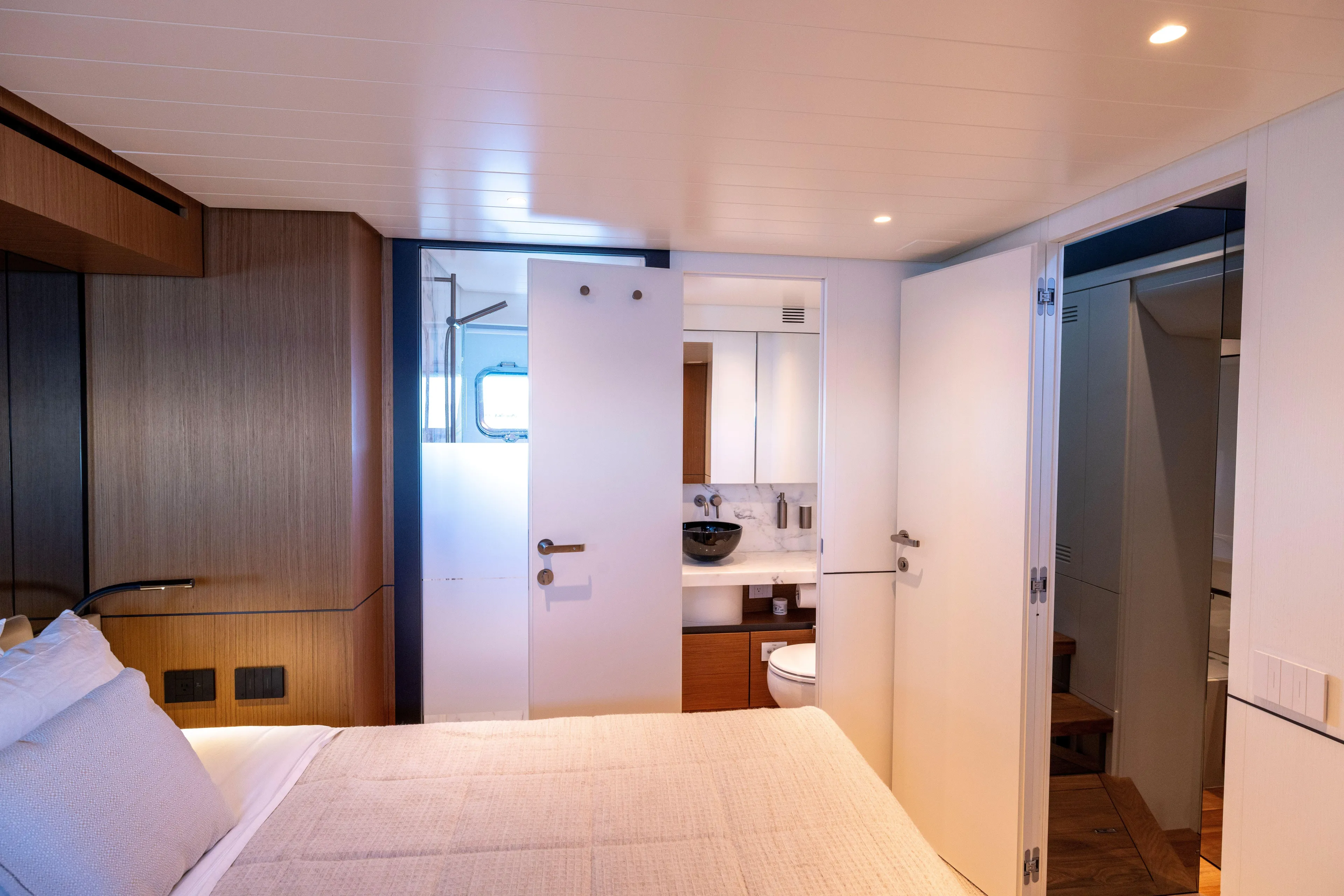 The Calm Down Yacht Photos Pics Luxurious interior of 2024 Bluegame BGX63 yacht featuring a modern bedroom and bathroom.