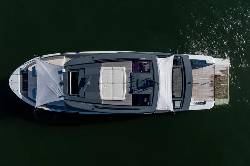 The Calm Down Yacht Photos Pics Overhead view of 2024 Bluegame BGX63 yacht with sunshades on calm water.