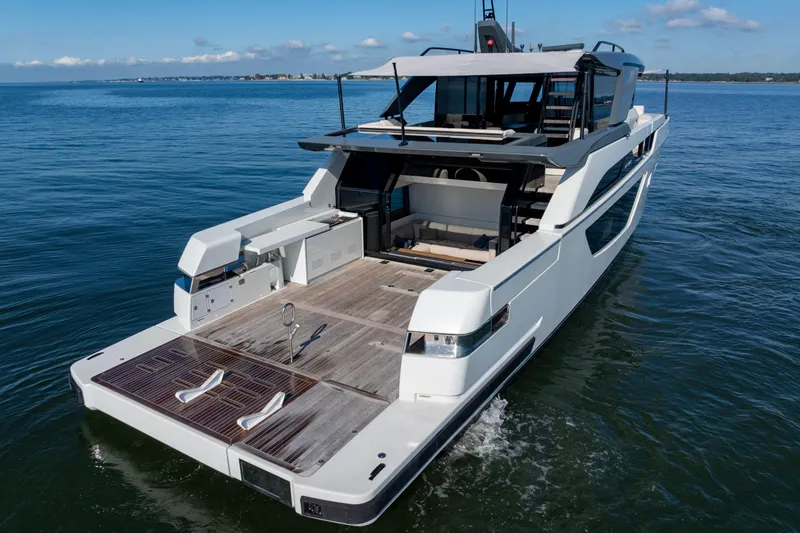 The Calm Down Yacht Photos Pics 2024 Bluegame BGX63 yacht on calm water, showcasing sleek design and spacious deck.