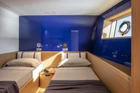 Luxurious twin cabin on 2024 Custom Line Navetta 30 yacht, featuring modern design and blue accents.