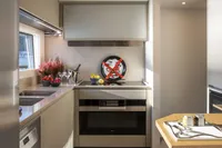 Modern kitchen interior on 2024 Custom Line Navetta 30 yacht, featuring sleek appliances and decor.