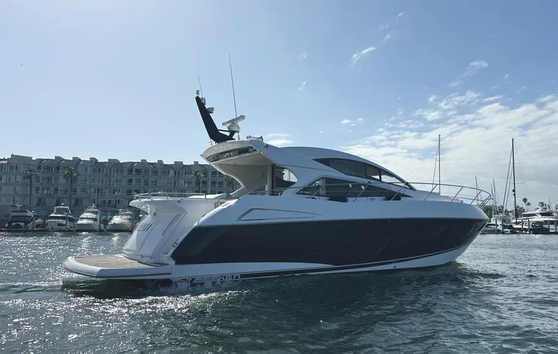 Tucker II Yacht Photos Pics 2015 Sunseeker Predator 57 yacht cruising in a marina under a clear sky.
