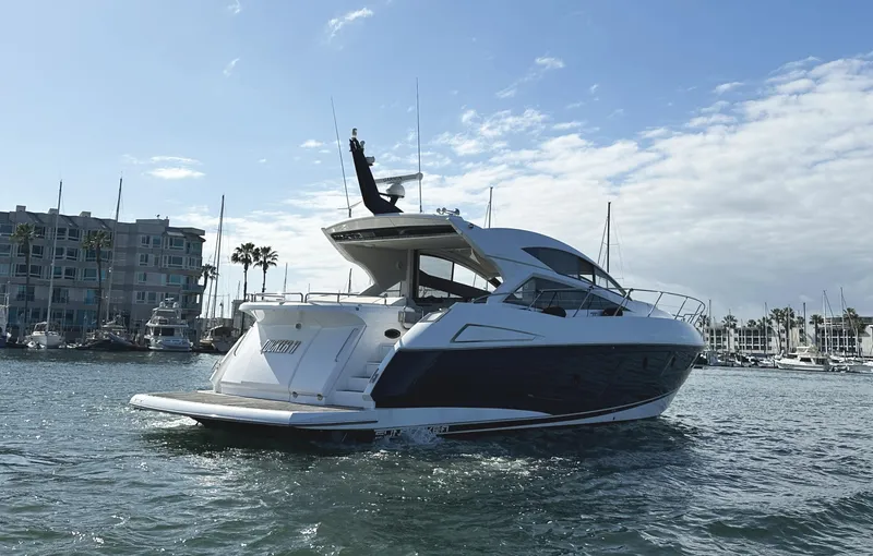 Tucker II Yacht Photos Pics 2015 Sunseeker Predator 57 yacht cruising in a marina under a partly cloudy sky.