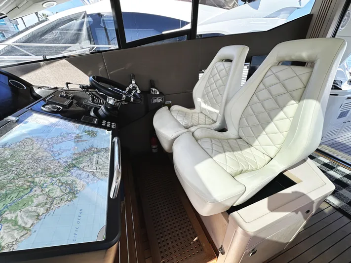 Tucker II Yacht Photos Pics Luxurious cockpit of 2015 Sunseeker Predator 57 yacht with white leather seats and navigation map.