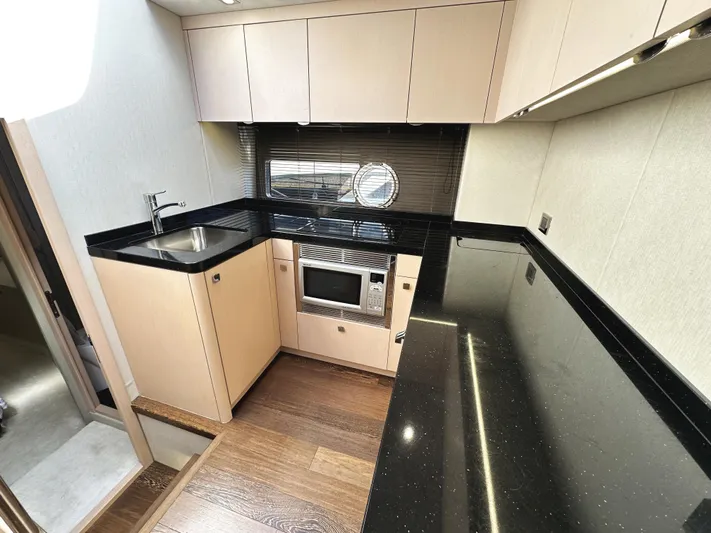 Tucker II Yacht Photos Pics Modern kitchen interior of 2015 Sunseeker Predator 57 yacht with sleek black countertops.