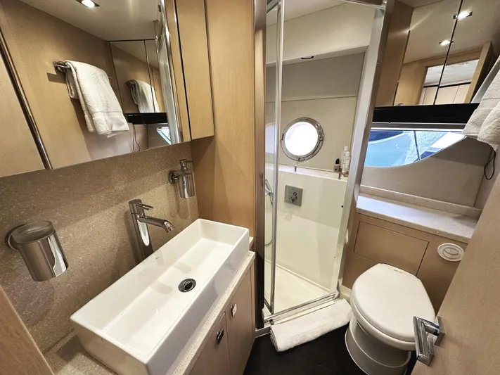 Tucker II Yacht Photos Pics Luxurious bathroom in 2015 Sunseeker Predator 57 yacht with modern fixtures and porthole window.