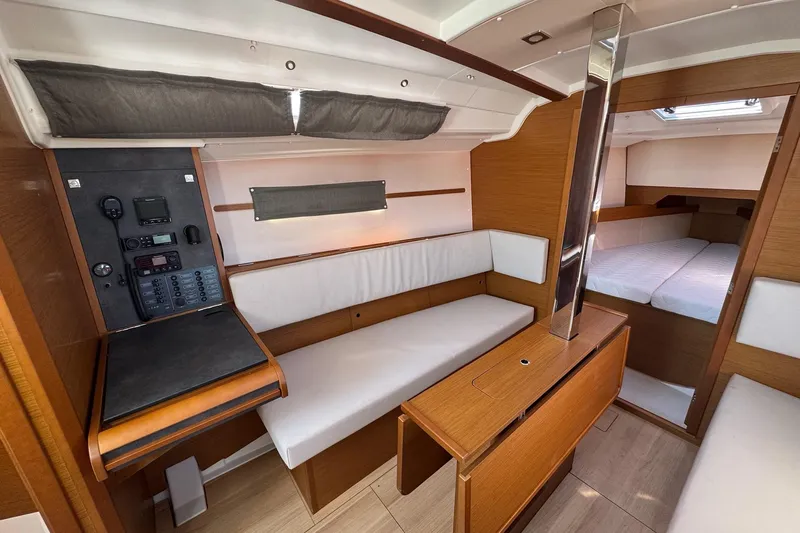  Yacht Photos Pics Interior of 2020 Jeanneau Sun Odyssey 349 sailboat, featuring cozy seating and navigation panel.
