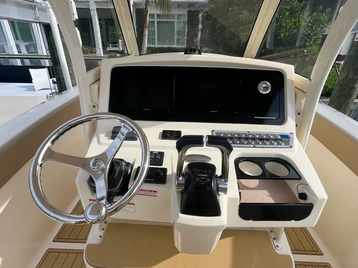 Outnumbered Yacht Photos Pics 2020 Scout 277LXF boat helm with steering wheel and control panel.