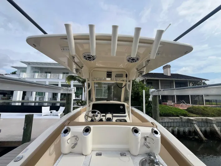 Outnumbered Yacht Photos Pics 2020 Scout 277LXF boat interior with rod holders and console, docked near waterfront homes.
