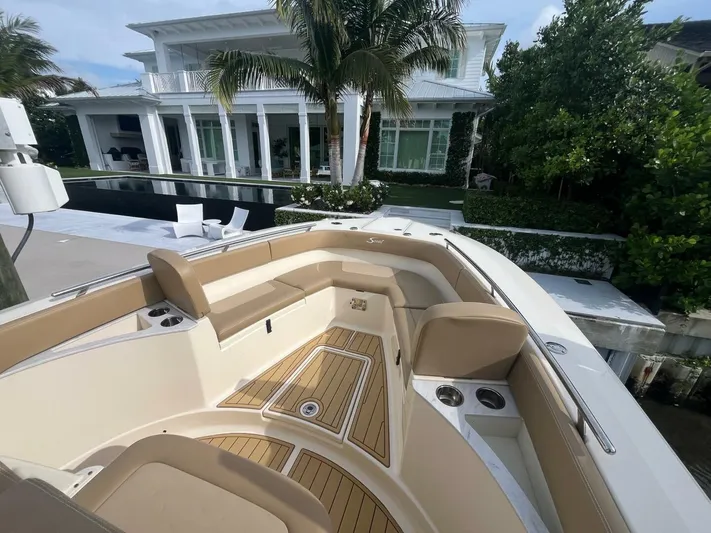 Outnumbered Yacht Photos Pics 2020 Scout 277LXF boat with luxurious seating, docked near a modern waterfront home.