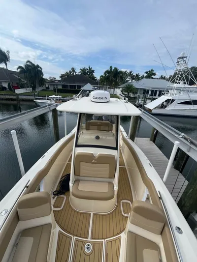 Outnumbered Yacht Photos Pics 2020 Scout 277LXF boat docked, featuring Garmin equipment, with elegant seating and scenic waterfront view.