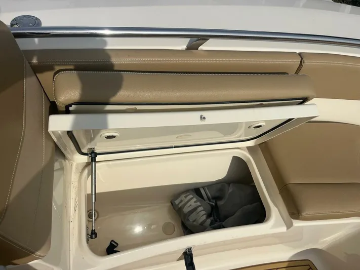 Outnumbered Yacht Photos Pics 2020 Scout 277LXF boat storage compartment with open lid and beige seating.