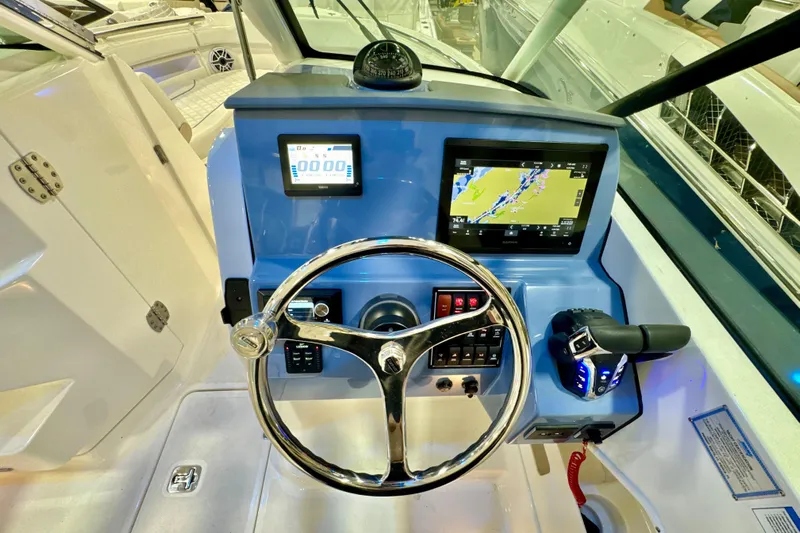  Yacht Photos Pics 2024 Pursuit DC 266 Dual Console boat dashboard with steering wheel and navigation screens.