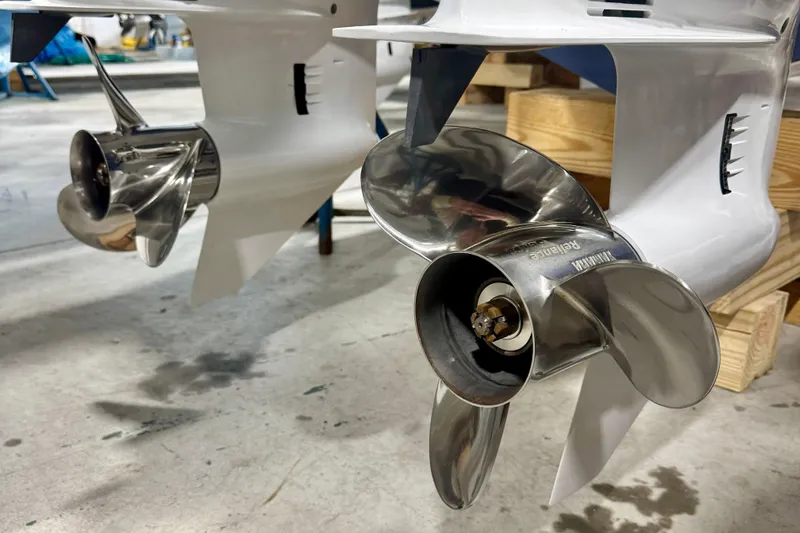  Yacht Photos Pics 2024 Pursuit DC 266 Dual Console boat propellers in a workshop setting.