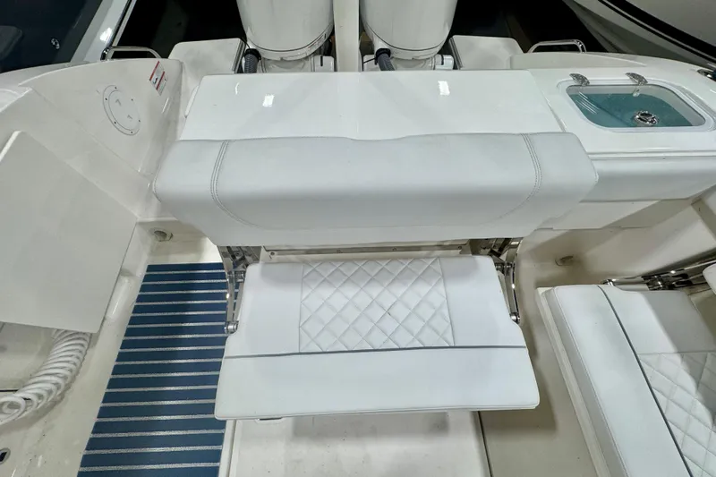  Yacht Photos Pics 2024 Pursuit DC 266 Dual Console boat interior with white seating and blue-striped flooring.