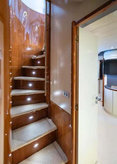  Yacht Photos Pics Interior staircase of 1996 Mochi Craft 25 Mega yacht with wooden finish and carpeted steps.