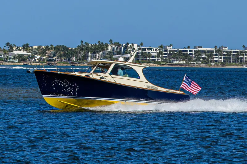 Cara Mia Yacht Photos Pics 2010 Hinckley Picnic Boat 37 MKIII cruising on blue water with American flag.
