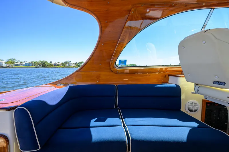 Cara Mia Yacht Photos Pics Hinckley Picnic Boat 37 MKIII interior with blue seating, wooden accents, and water view.