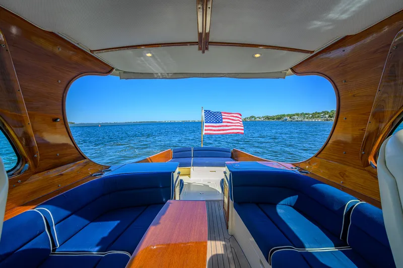 Cara Mia Yacht Photos Pics Hinckley Picnic Boat 37 MKIII interior with American flag, blue seating, and ocean view.