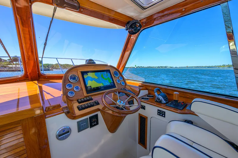 Cara Mia Yacht Photos Pics Helm of 2010 Hinckley Picnic Boat 37 MKIII with navigation system, overlooking serene waters.