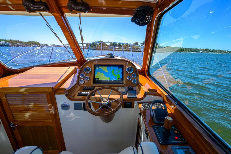 Cara Mia Yacht Photos Pics Helm of 2010 Hinckley Picnic Boat 37 MKIII with navigation system, steering wheel, and scenic water view.