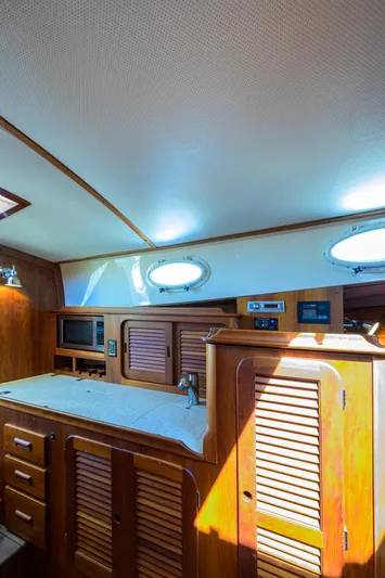 Cara Mia Yacht Photos Pics Interior of 2010 Hinckley Picnic Boat 37 MKIII with wooden cabinetry and porthole windows.