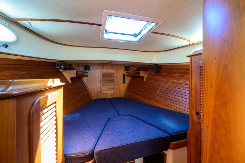Cara Mia Yacht Photos Pics Cozy cabin interior of 2010 Hinckley Picnic Boat 37 MKIII with wooden paneling and blue cushions.
